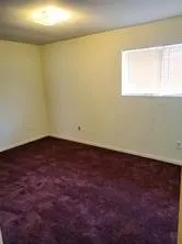 an empty room with a ceiling fan and window