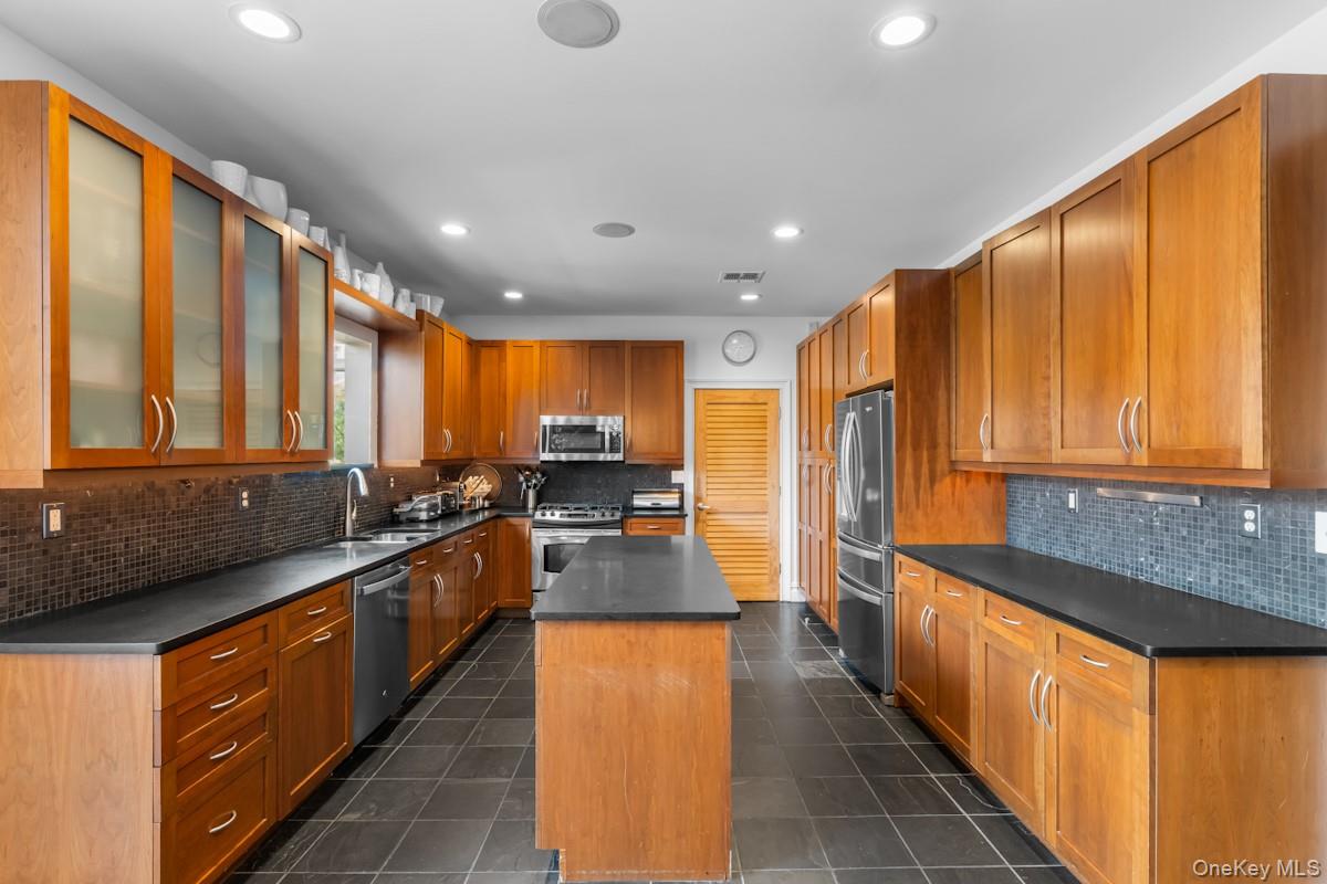 9 Ronwood Road Chestnut Ridge, NY 10977 - Photo 15 of 48 a large kitchen with stainless steel appliances a large counter top a stove top oven a sink and a refrigerator