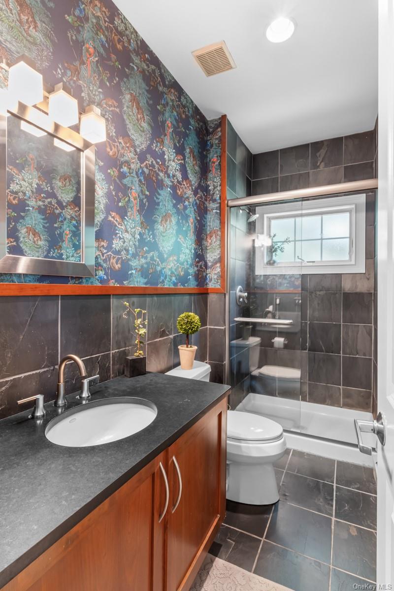 9 Ronwood Road Chestnut Ridge, NY 10977 - Photo 19 of 48 a bathroom with a granite countertop sink a toilet a mirror and shower