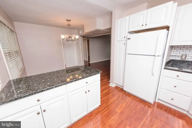 a kitchen with granite countertop a refrigerator and a sink