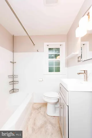 a bathroom with a sink toilet vanity and tub