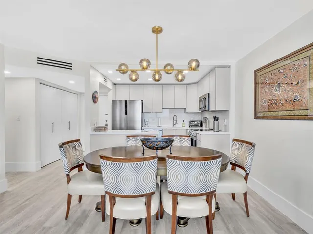 a view of a dining room with furniture a chandelier and wooden floor