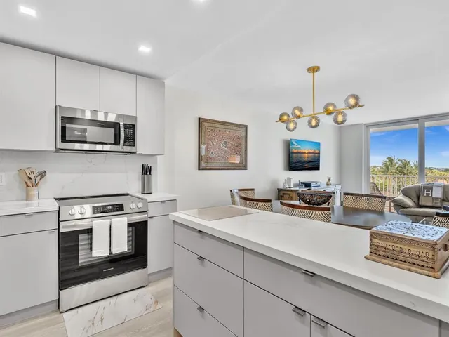 a kitchen with stainless steel appliances a stove a sink a microwave a refrigerator and cabinets