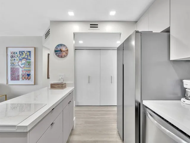 a kitchen with stainless steel appliances granite countertop a refrigerator sink and cabinets
