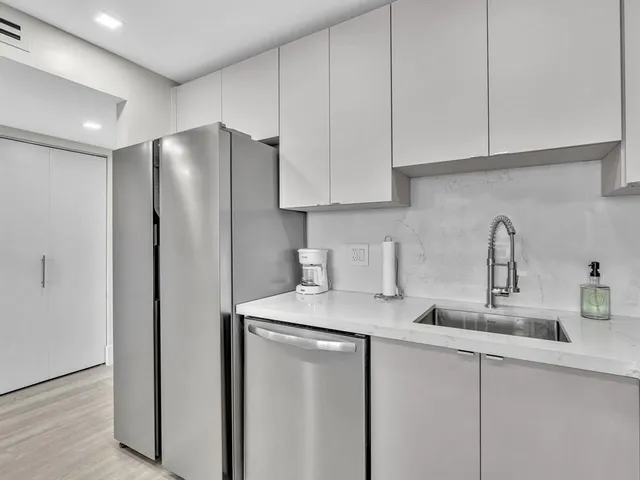 a kitchen with stainless steel appliances granite countertop white cabinets a sink and dishwasher