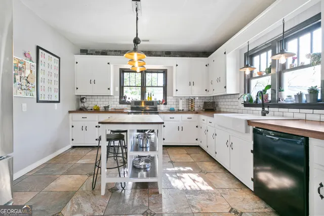 a kitchen with stainless steel appliances kitchen island granite countertop a sink a stove a refrigerator and a dining table with wooden floor