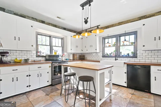 a kitchen with granite countertop a sink window and cabinets