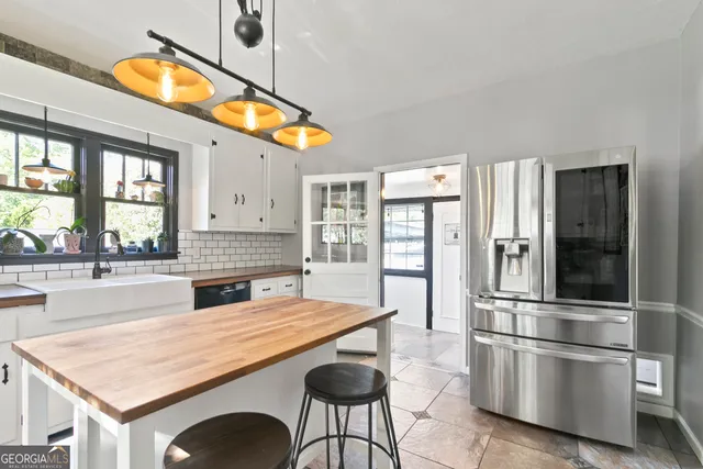 a kitchen with stainless steel appliances granite countertop a refrigerator a stove and a wooden floors