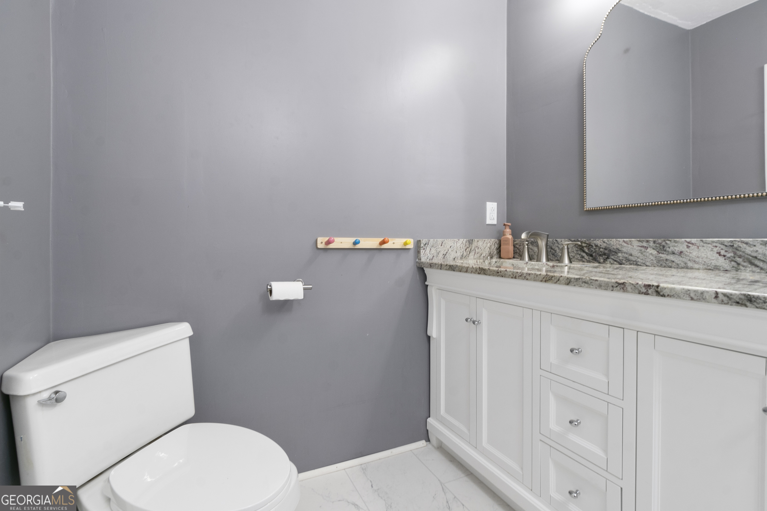 61 Clark Street Newnan, GA 30263 - Photo 16 of 37 a bathroom with a granite countertop toilet sink and mirror