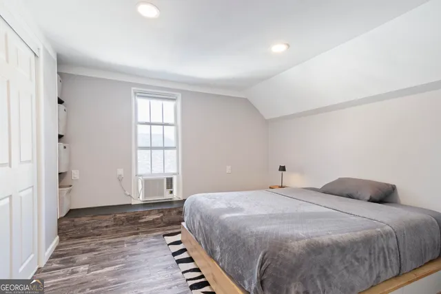 a bedroom with a bed and wooden floor