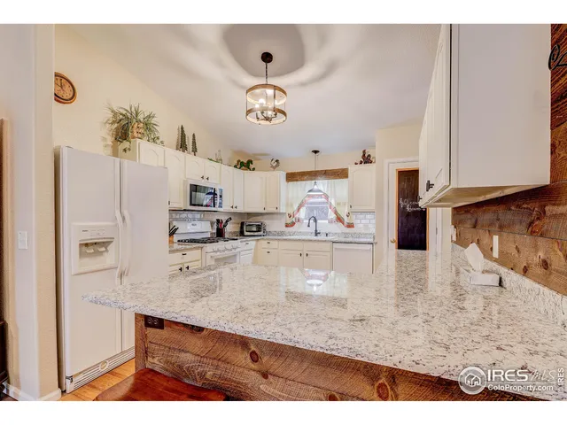 a kitchen with stainless steel appliances granite countertop a sink a refrigerator and a stove