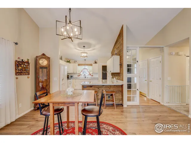 a dining room with wooden floor a chandelier a wooden table and chairs
