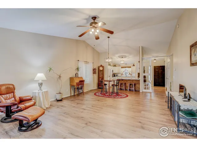 a living room with furniture and a dining table with wooden floor