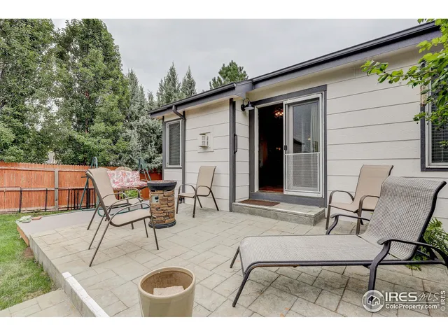 a view of a patio with table and chairs with wooden floor and fence
