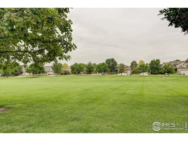 a view of a green field with wooden fence
