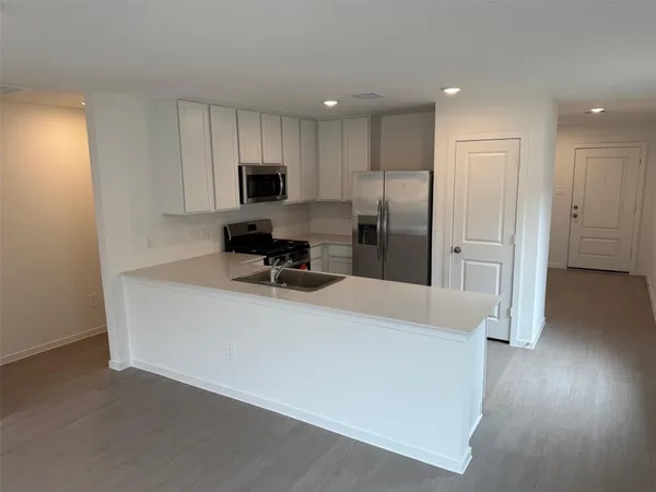 a view of kitchen with stainless steel appliances refrigerator stove microwave and cabinets