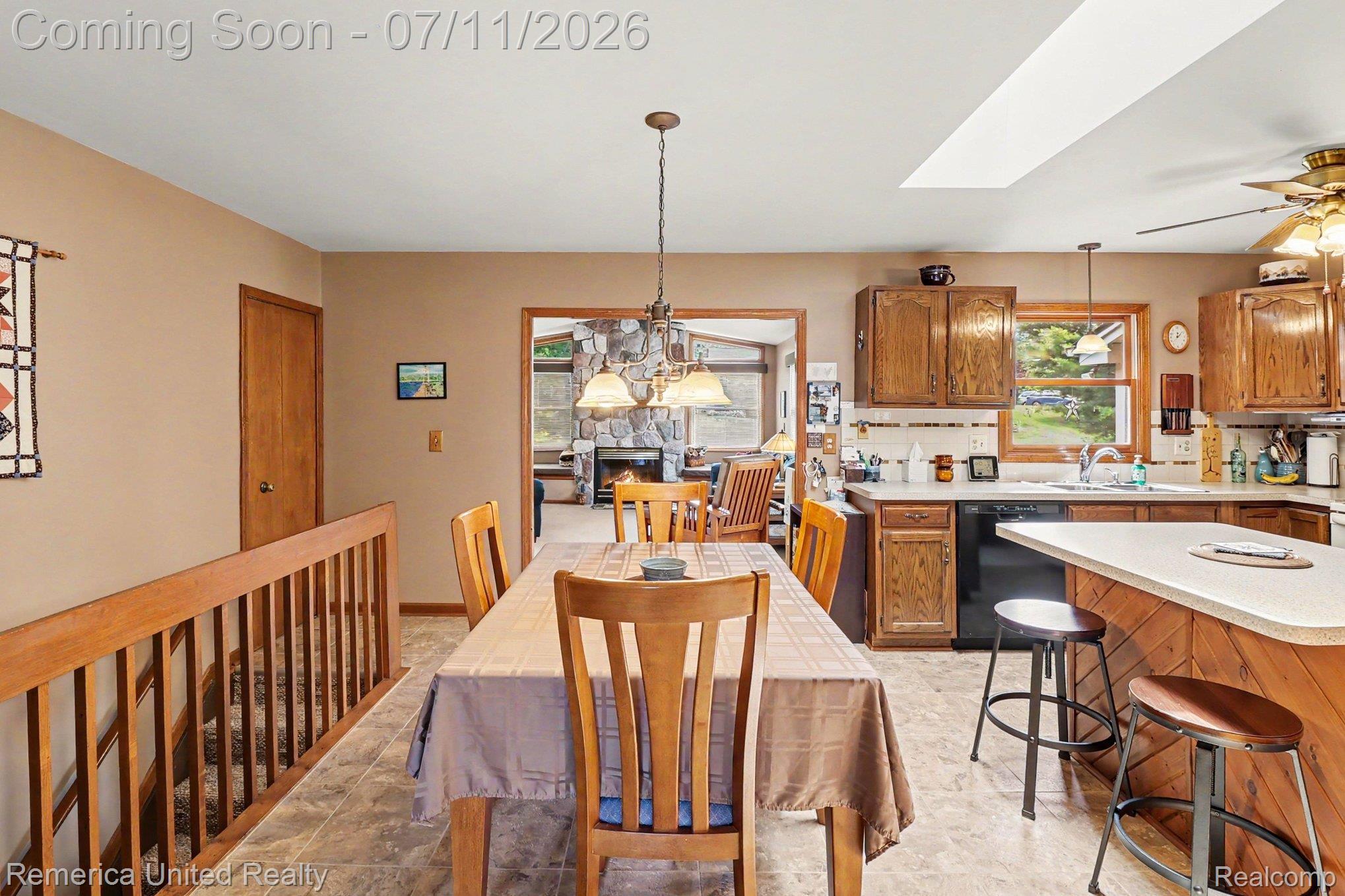 136 Endicott Howell, MI 48843 - Photo 9 of 28 Kitchen and dining area featuring wood-finish cabinetry, a skylight, and a ceiling fan
