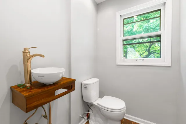 a bathroom with a toilet a sink and a window