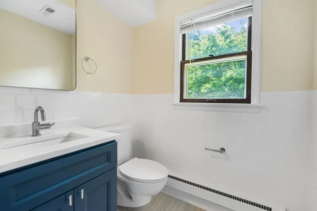 a bathroom with a sink vanity mirror and toilet