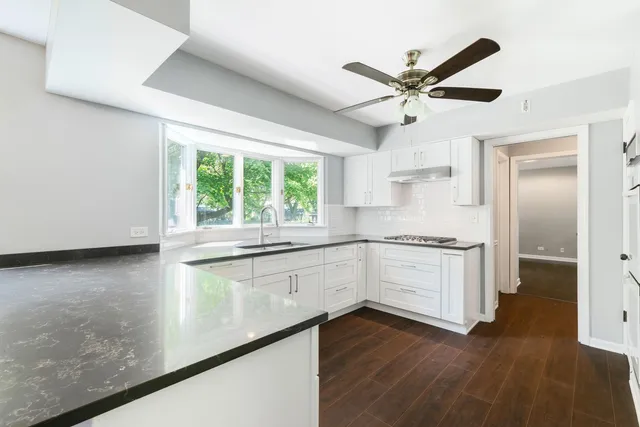 a kitchen with a refrigerator and white cabinets
