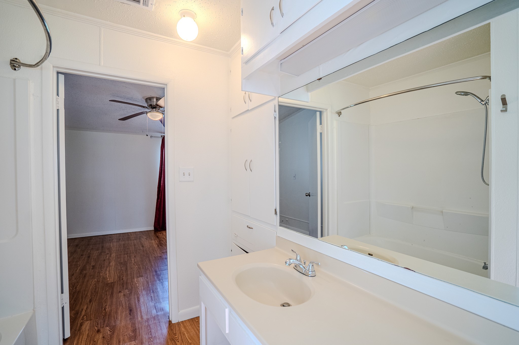 16013 Edwards Drive Austin, TX 78734 - Photo 14 of 18 A well-appointed bathroom features a practical vanity with built-in storage and a pristine tub/shower combination.