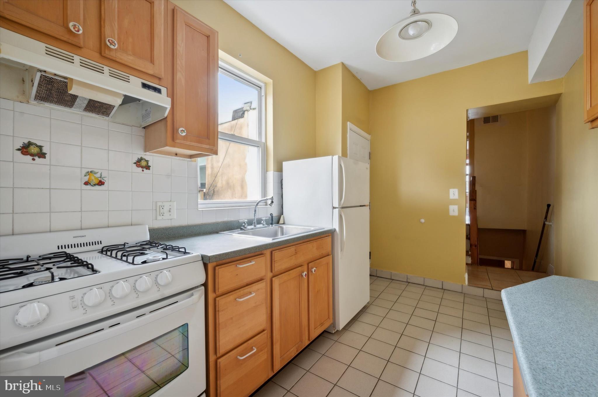 519 South 17th Street, Unit 3 Philadelphia, PA 19146 - Photo 2 of 8 a kitchen with granite countertop a stove a sink and a refrigerator