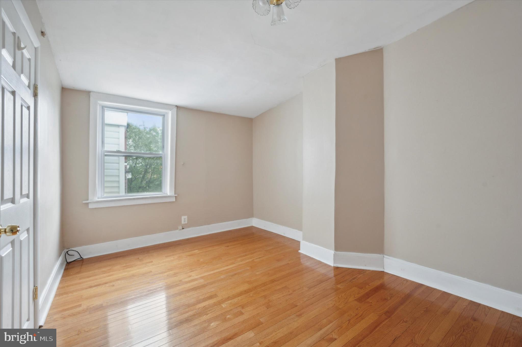 519 South 17th Street, Unit 3 Philadelphia, PA 19146 - Photo 6 of 8 a view of an empty room with wooden floor and a window