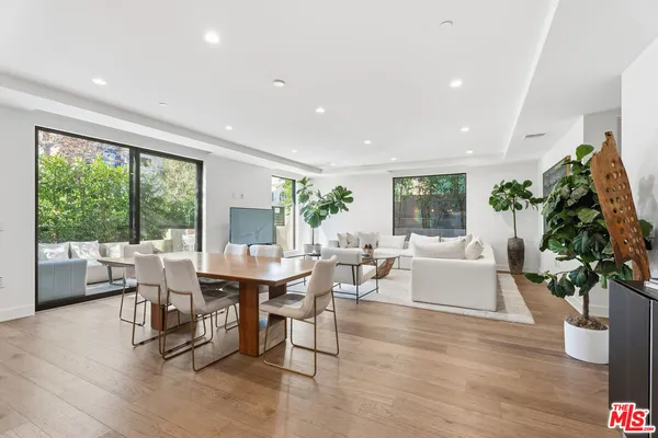 a dining room with furniture window and wooden floor