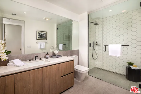 a bathroom with a double vanity sink toilet mirror and shower