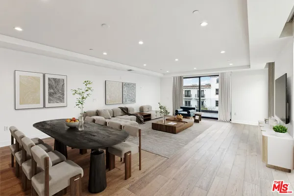 a living room with furniture a flat screen tv and a dining table