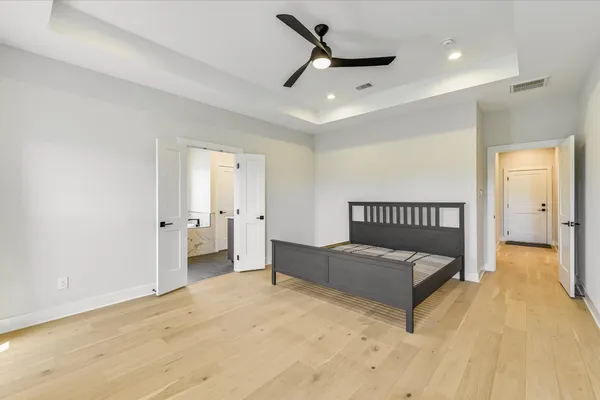 a spacious bedroom with a bed and a ceiling fan