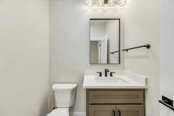 a bathroom with a sink a toilet and mirror
