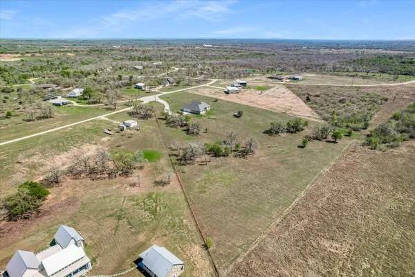 an aerial view of a house with a yard and lake view