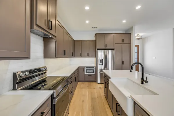 a kitchen with sink refrigerator and microwave