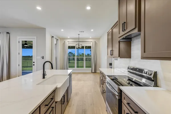 a kitchen with granite countertop a sink stainless steel appliances and cabinets