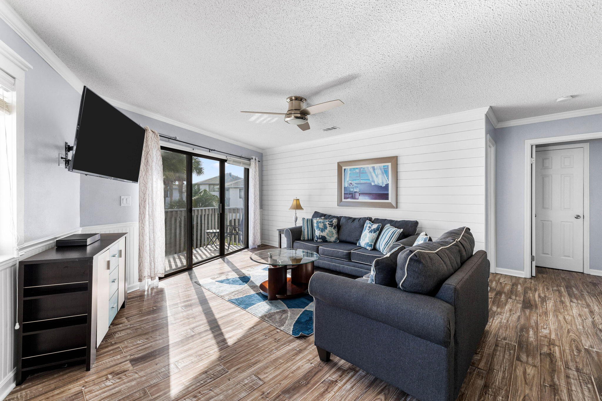 285 Payne Street, Unit 19B Destin, FL 32550 - Photo 5 of 29 a living room with furniture a flat screen tv and a floor to ceiling window
