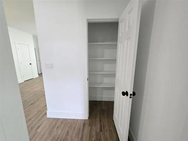 a view of a hallway with wooden floor and entryway
