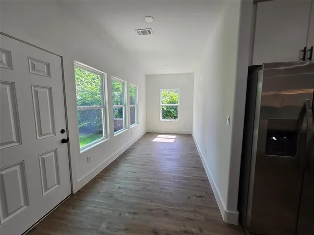 a view of a hallway with wooden floor and stairs
