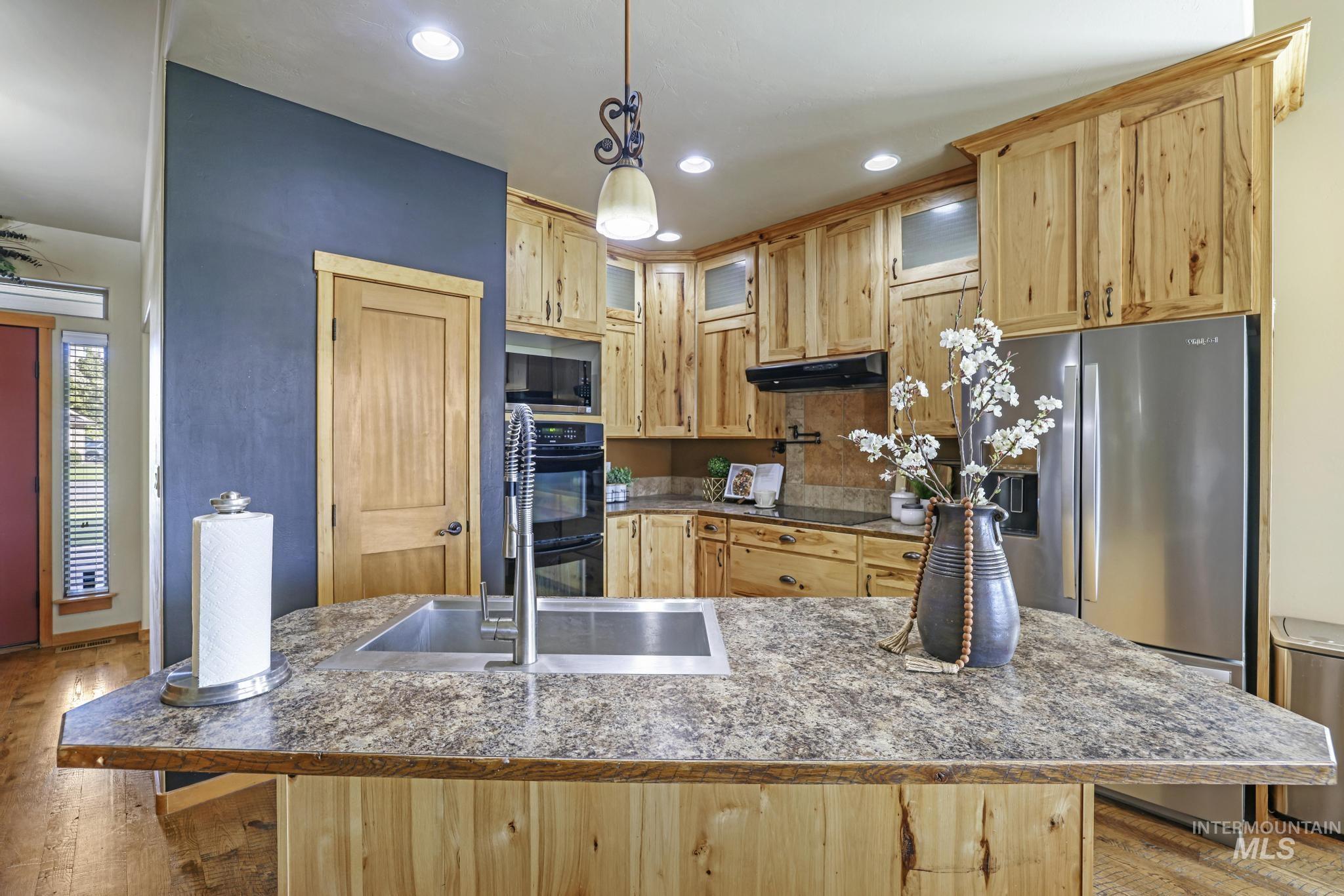 205 Edwards Drive Twin Falls, ID 83301 - Photo 13 of 49 Kitchen featuring light brown cabinetry, stainless steel refrigerator with ice dispenser, decorative light fixtures, light wood-style flooring, and recessed lighting