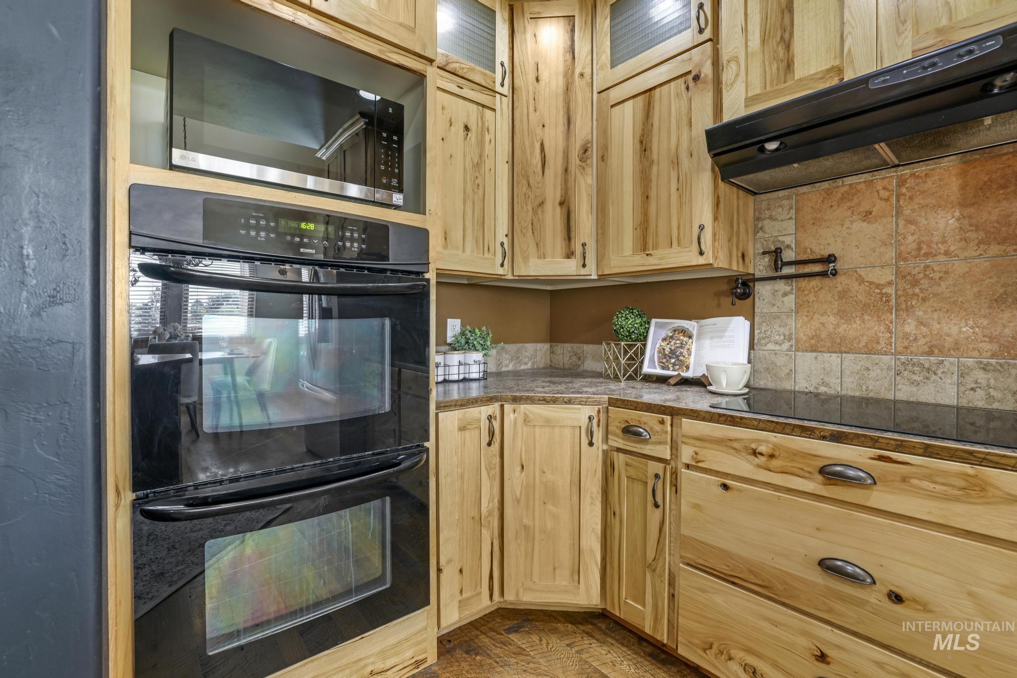 205 Edwards Drive Twin Falls, ID 83301 - Photo 16 of 49 Kitchen featuring black appliances, under cabinet range hood, and light brown cabinets