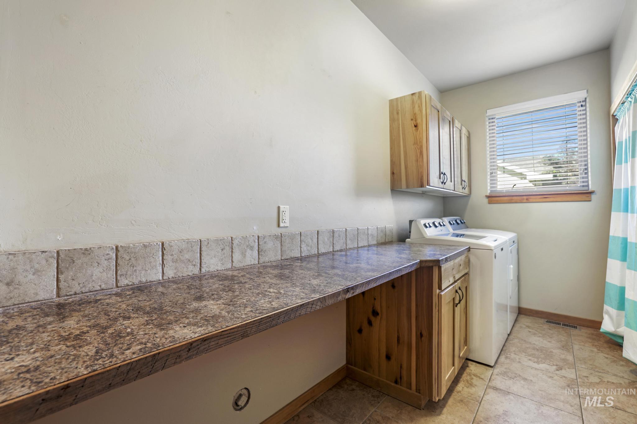 205 Edwards Drive Twin Falls, ID 83301 - Photo 36 of 49 Laundry room with independent washer and dryer, light tile patterned floors, and cabinet space