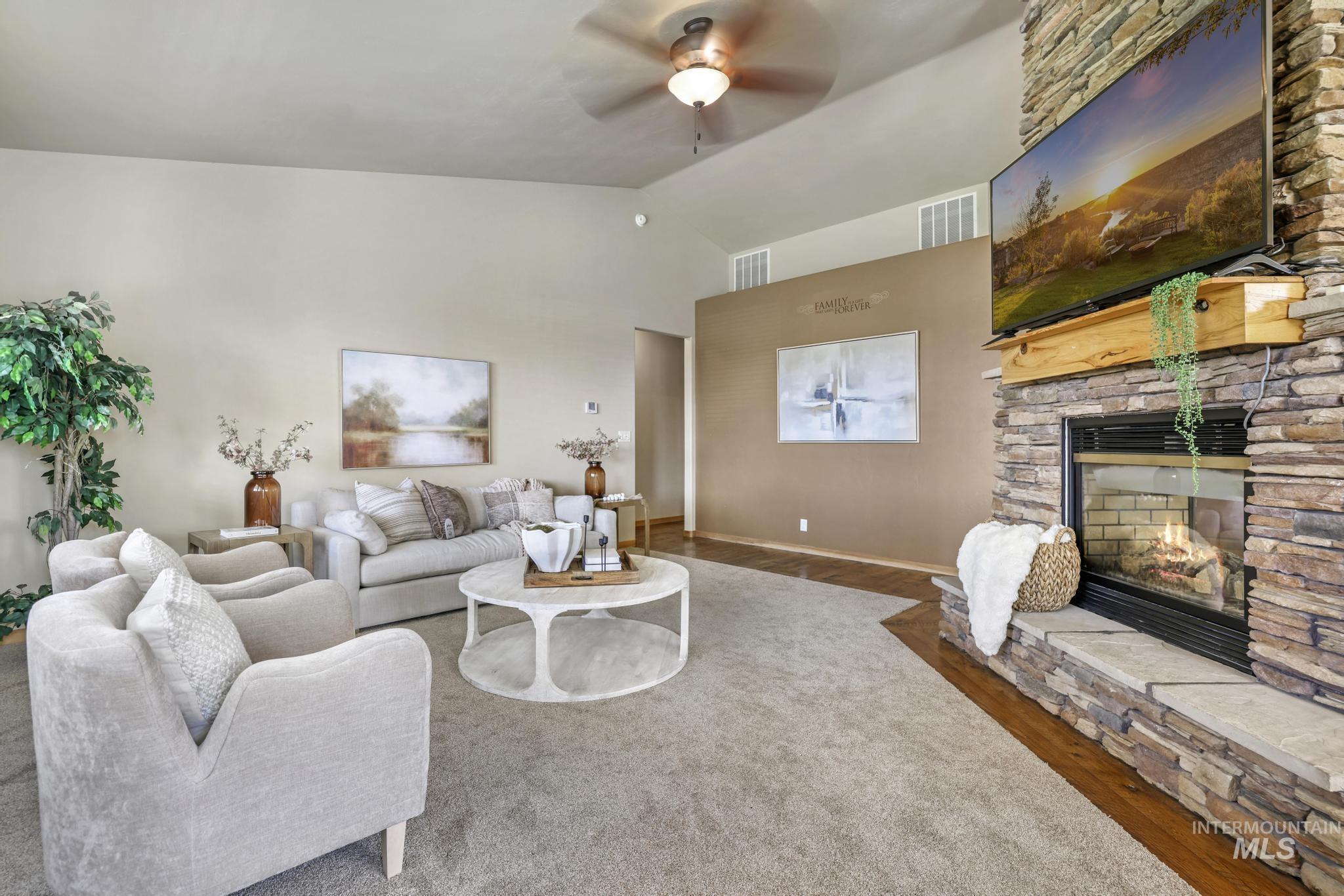 205 Edwards Drive Twin Falls, ID 83301 - Photo 7 of 49 Living area with vaulted ceiling, wood finished floors, ceiling fan, and a stone fireplace