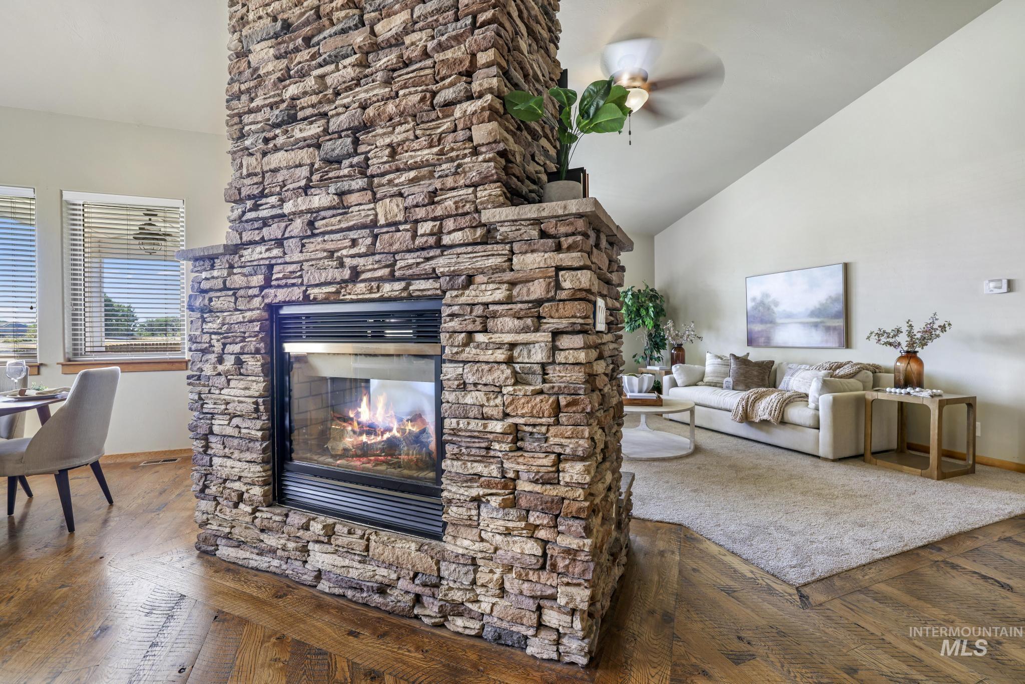 205 Edwards Drive Twin Falls, ID 83301 - Photo 8 of 49 Living room with dark wood-type flooring, a stone fireplace, a ceiling fan, and vaulted ceiling