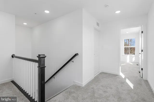a view of a hallway with wooden floor and entryway