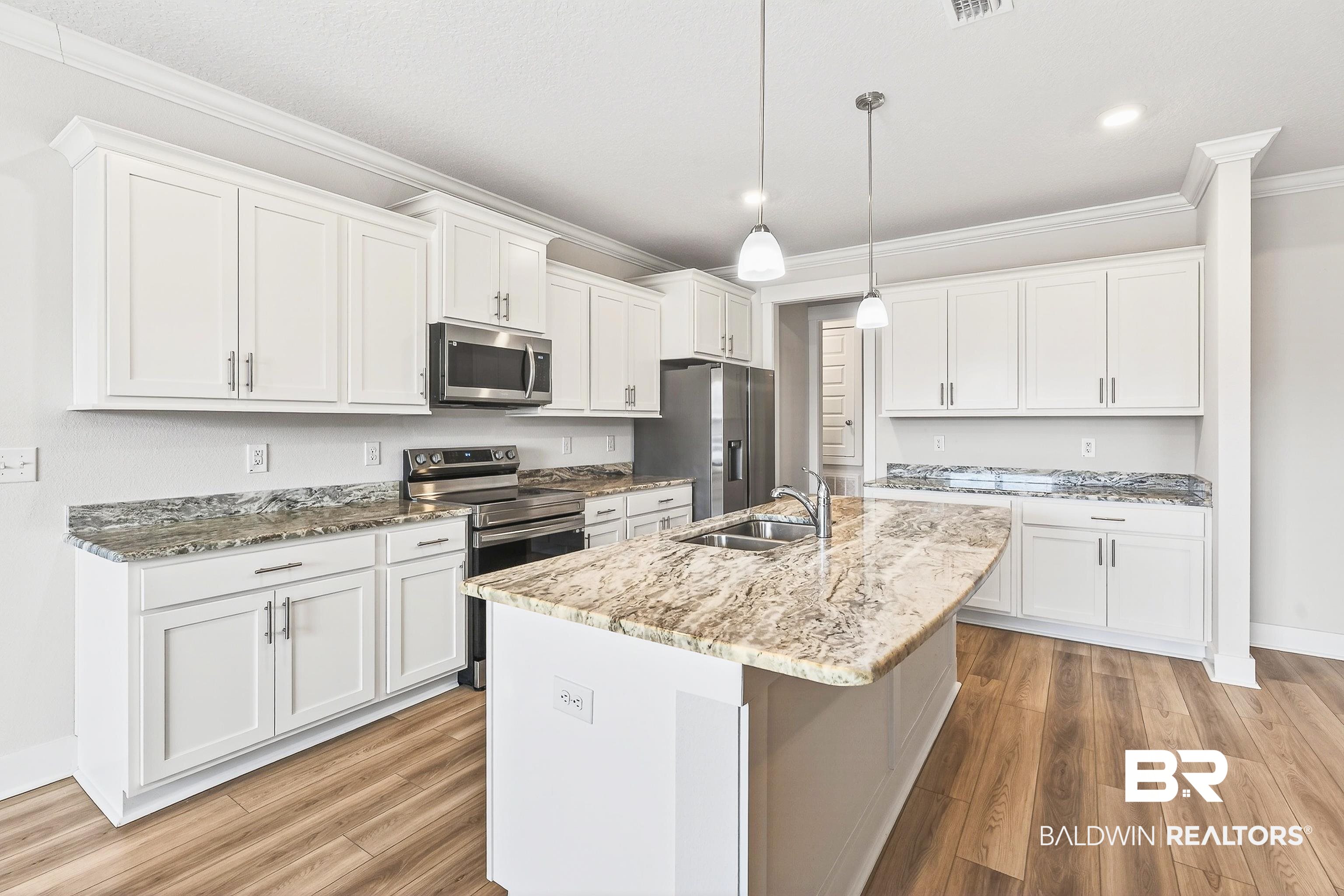 1728 Partridge Street Foley, AL 36535 - Photo 11 of 37 Kitchen with stainless steel appliances, white cabinets, crown molding, pendant lighting, and light wood-type flooring