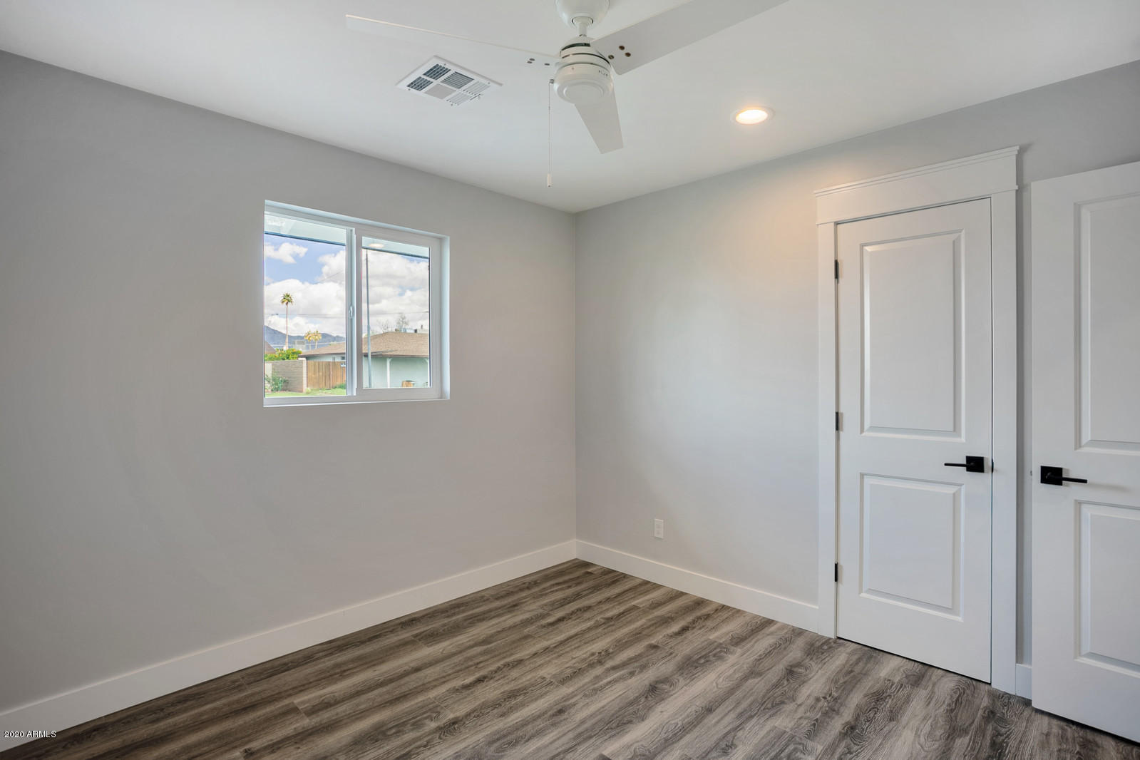 4917 East Granada Road Phoenix, AZ 85008 - Photo 14 of 18 a view of an empty room with wooden floor and a window