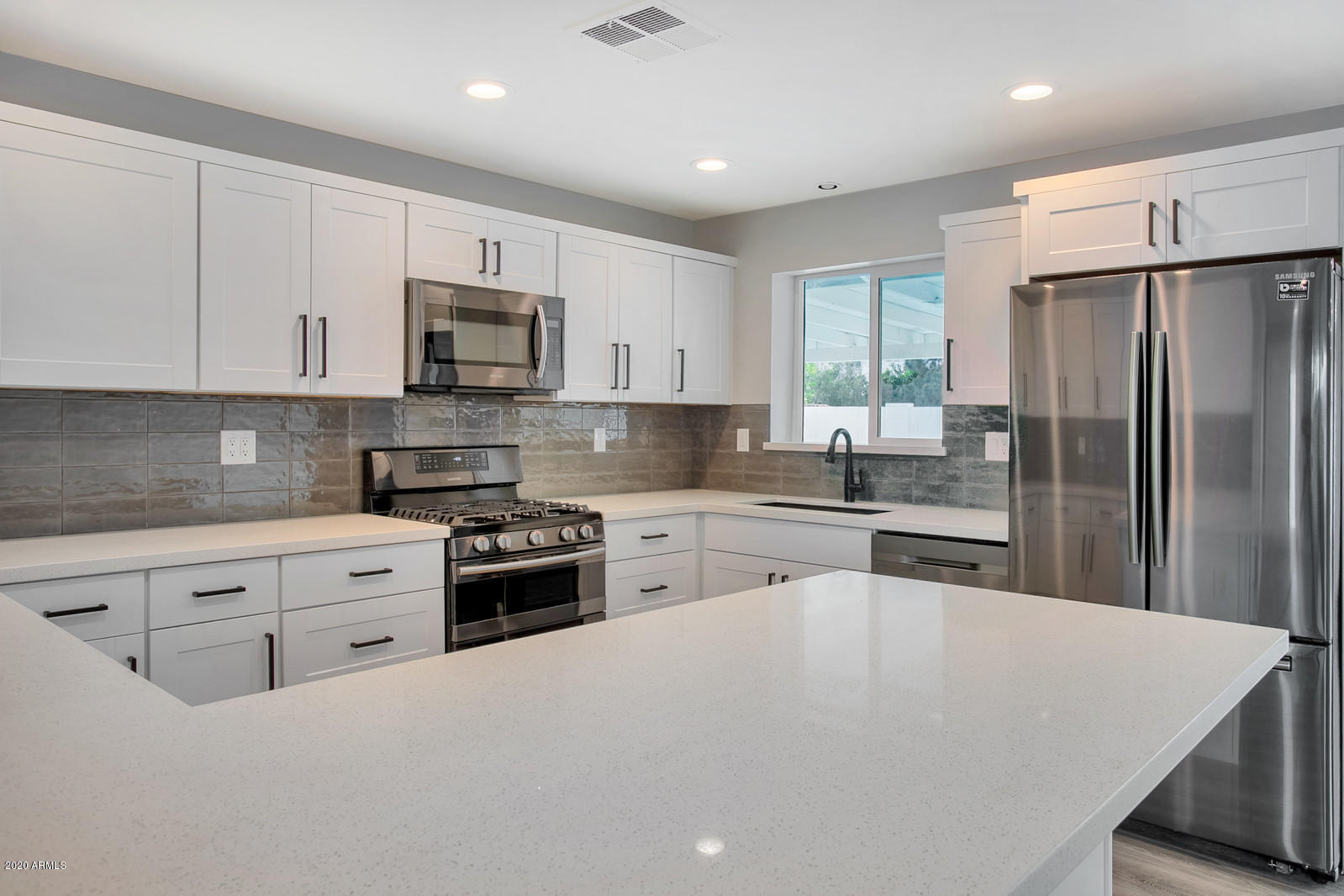 4917 East Granada Road Phoenix, AZ 85008 - Photo 5 of 18 a kitchen with granite countertop white cabinets and stainless steel appliances