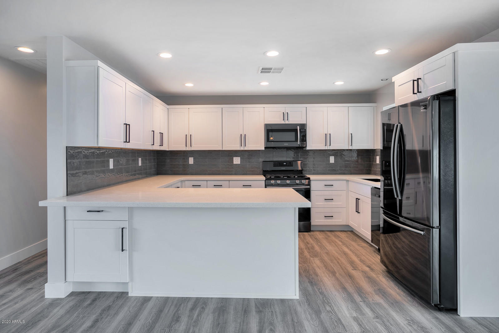 4917 East Granada Road Phoenix, AZ 85008 - Photo 6 of 18 a kitchen with kitchen island a white counter top space stainless steel appliances and cabinets