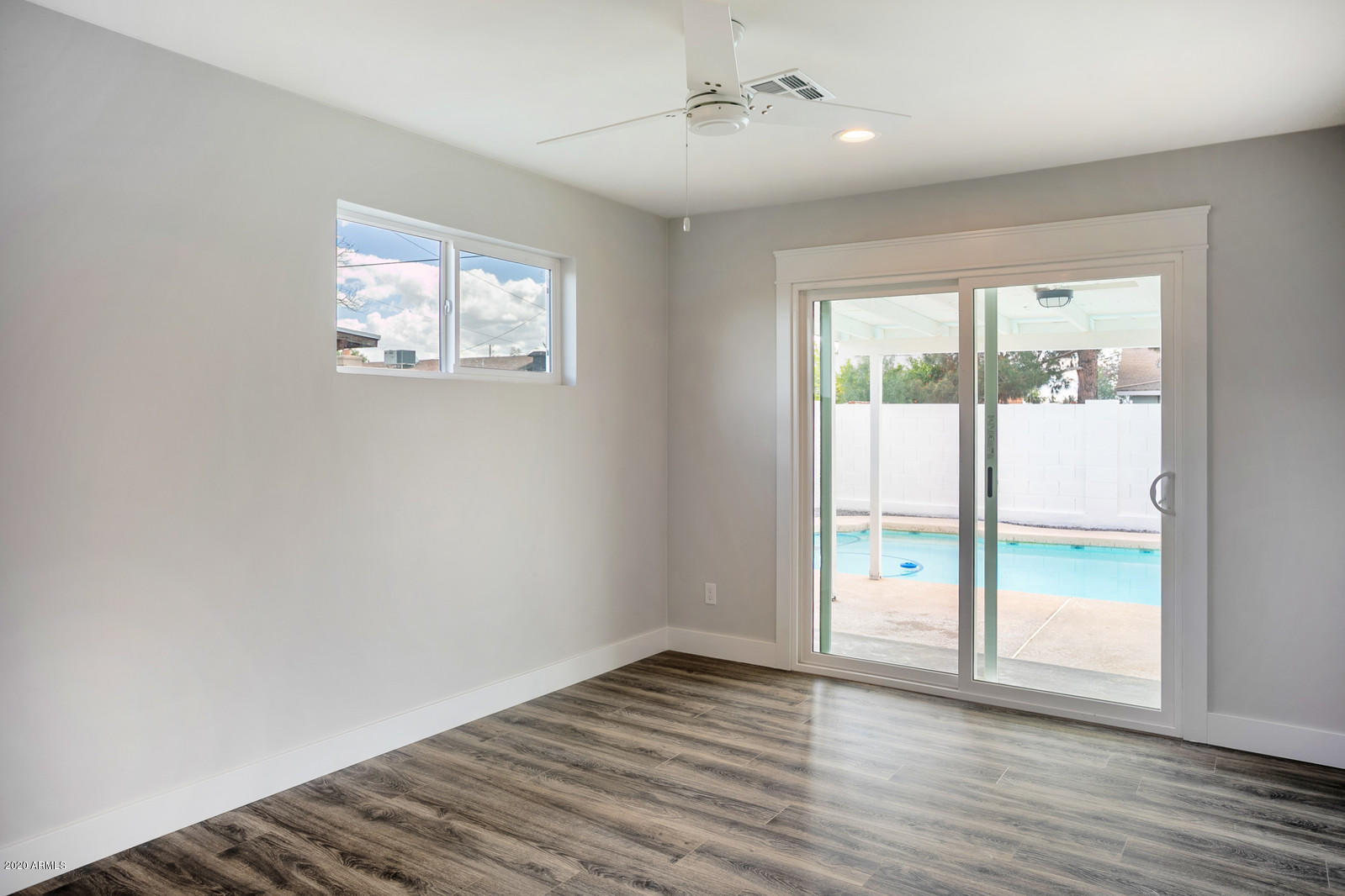 4917 East Granada Road Phoenix, AZ 85008 - Photo 9 of 18 a view of an empty room with wooden floor and a window