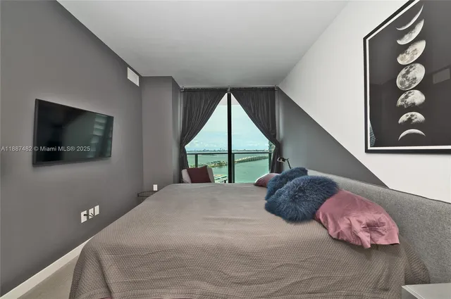 a bedroom with a bed and a flat screen tv